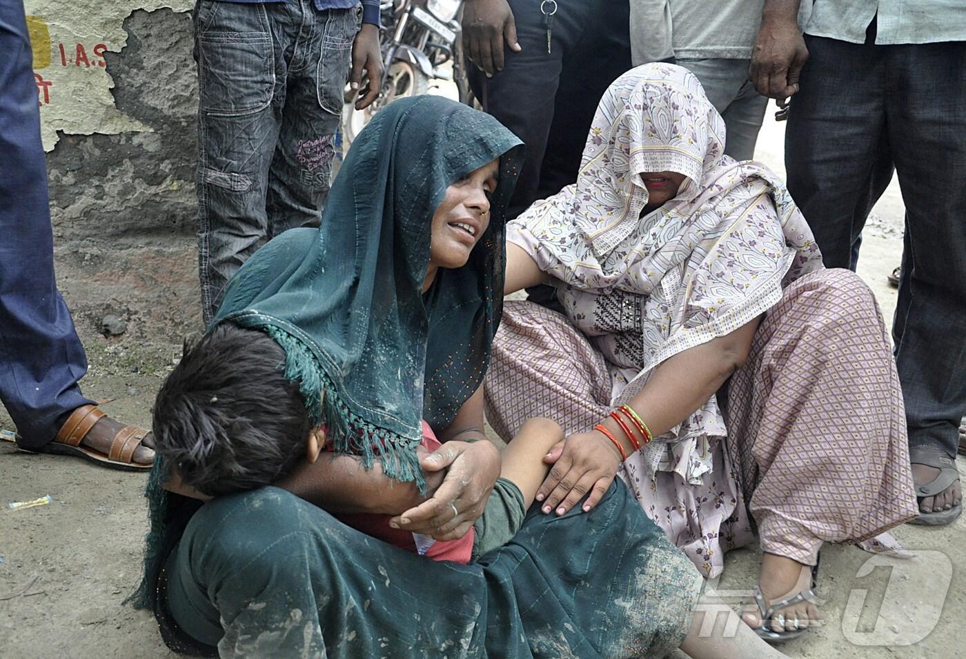 2일&#40;현지시간&#41; 인도 북부 우타르프라데시주 하트라스에서 발생한 압사사고로 한 여성이 아이를 안고 슬픔에 잠겨있다. 2024.07.02 ⓒ 로이터=뉴스1 ⓒ News1 정지윤 기자